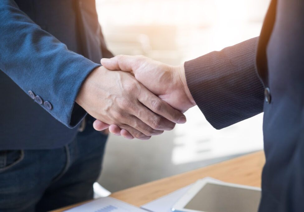 Two confident business man shaking hands during a meeting in the office, success, dealing, greeting and partner concept